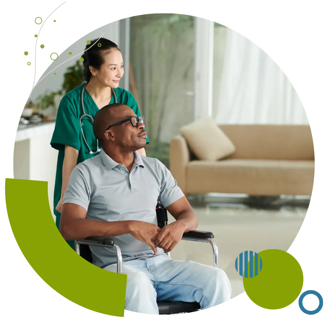 Home care professional standing behind an older adult using a wheelchair, representing supportive home care services in Columbus, OH.
