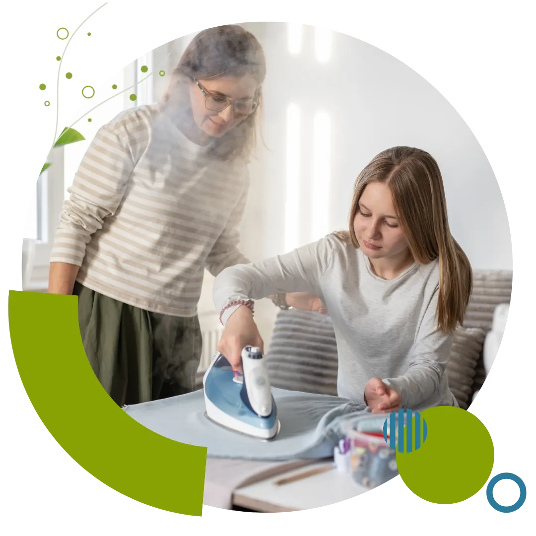 Homemaking caregiver assisting an older woman with ironing and routine household tasks at home in Columbus, OH.